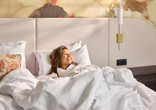 persoon in bed met koffie en valk magazine