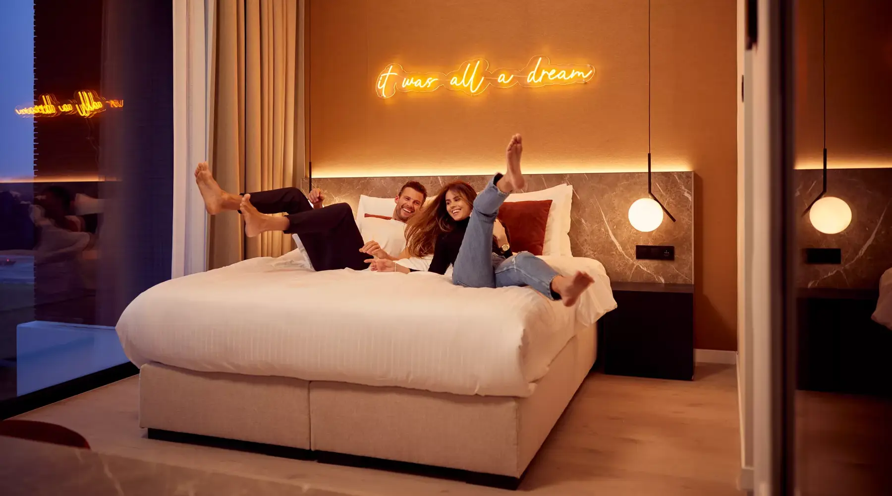 man and woman jumping on bed