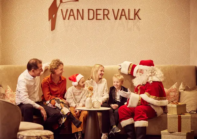 Familie sitzt mit dem Weihnachtsmann in der Lobby