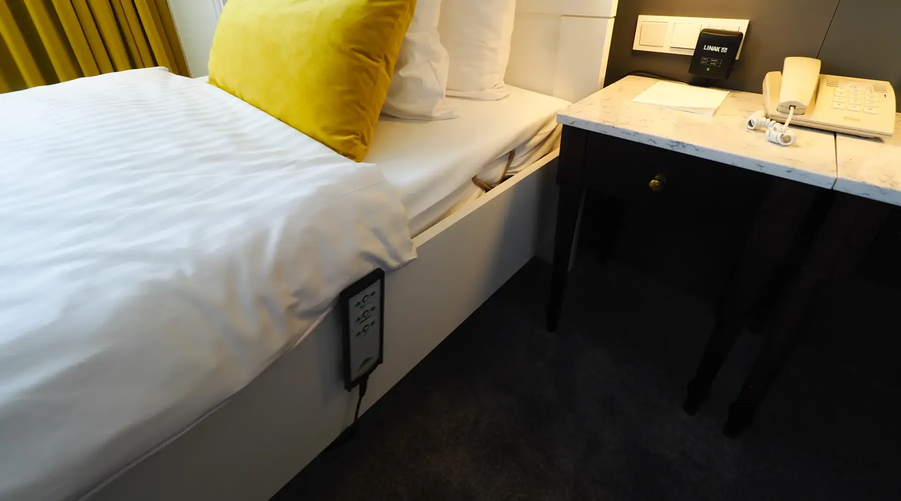 Electrically height-adjustable single bed in the wheelchair-accessible room
