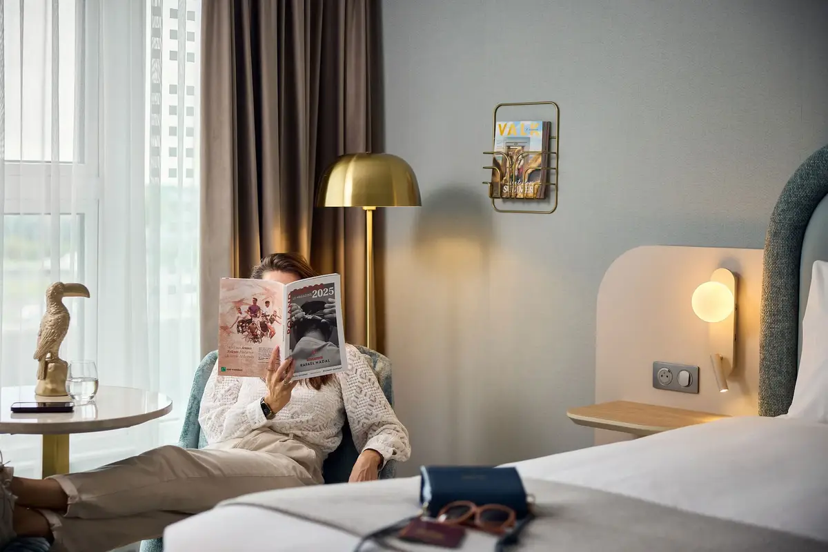Invité avec un magazine dans une chambre d'hôtel Valk