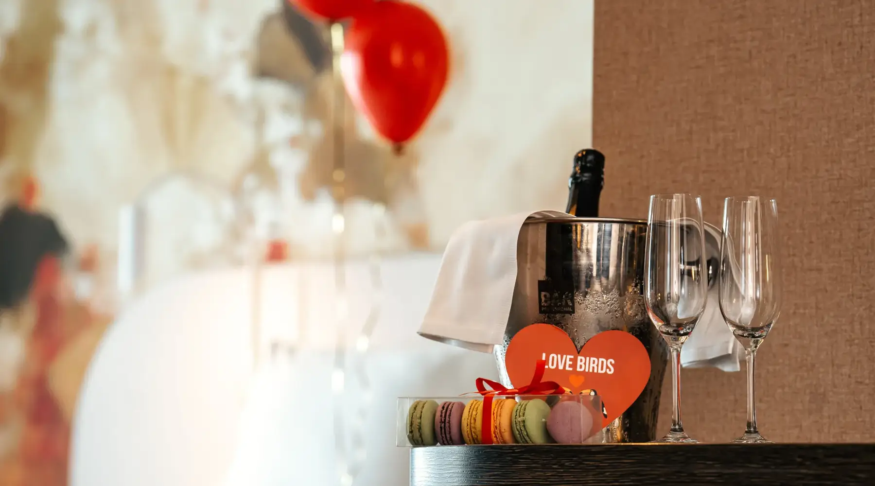 macarons met fles champagne bij bed