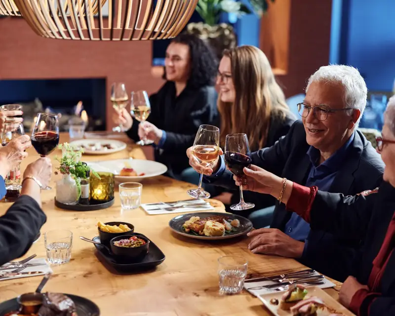 People clinking glasses at the table