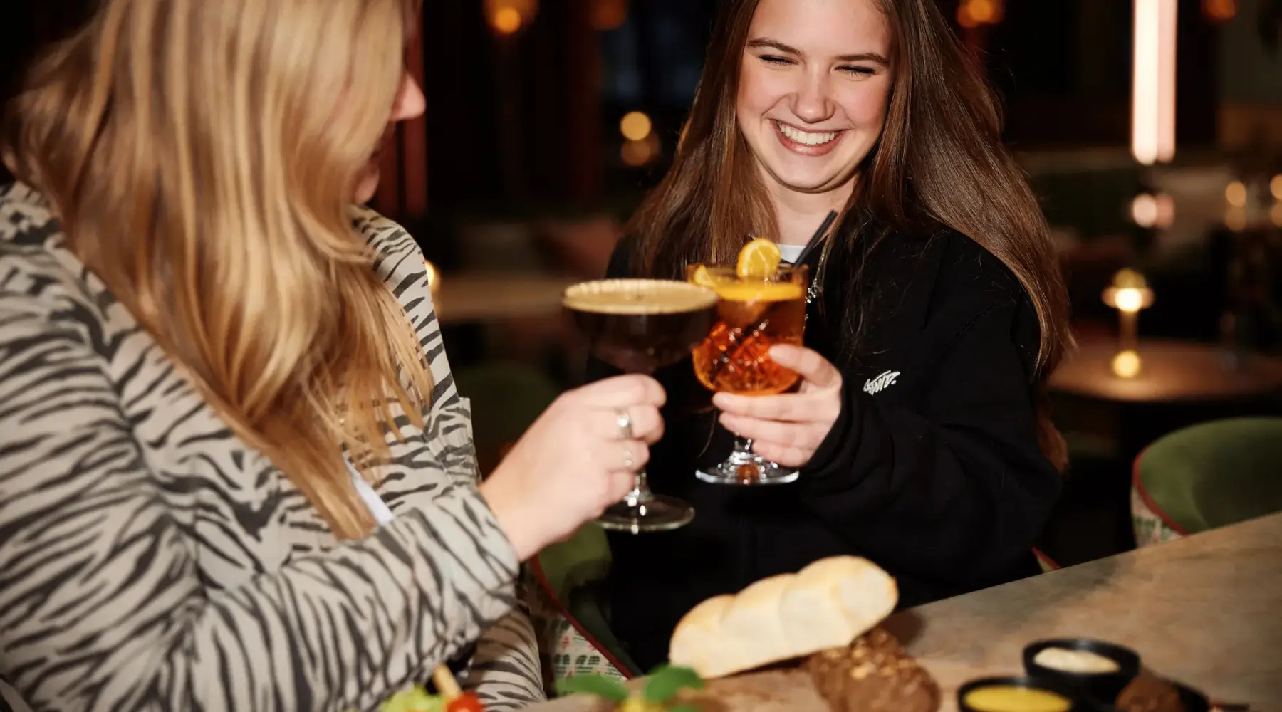 Gäste stoßen während eines festlichen Abendessens im Van der Valk Hotel Texel – De Koog an.