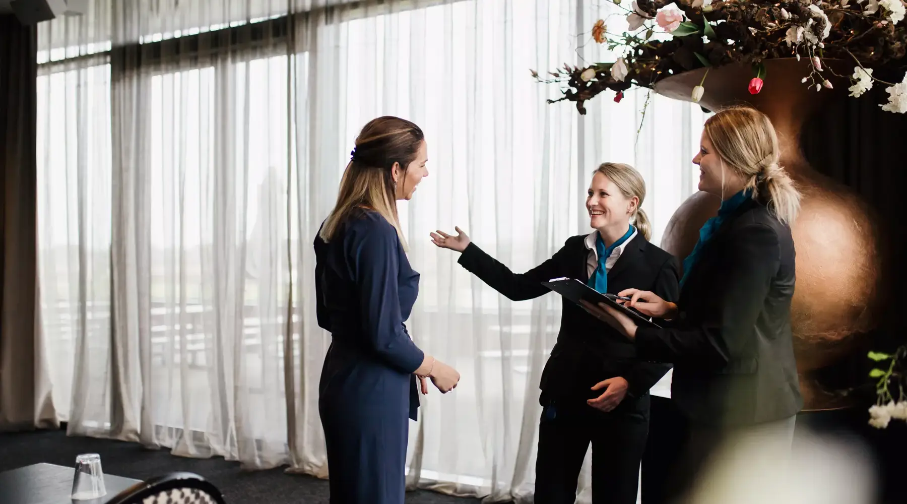 Employé de l'hôtel montre une salle de réunion aux clients.