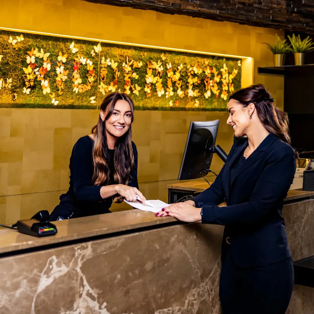 Friends checking in at the reception of a hotel
