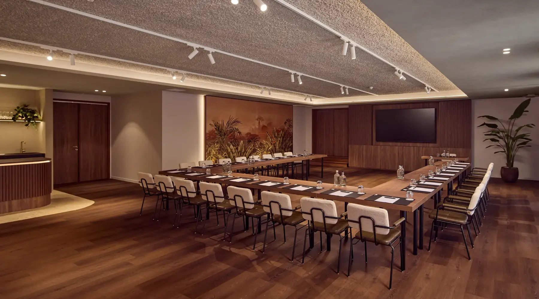 Saal im Hotel Dennenhof mit Stühlen und Großbildschirm