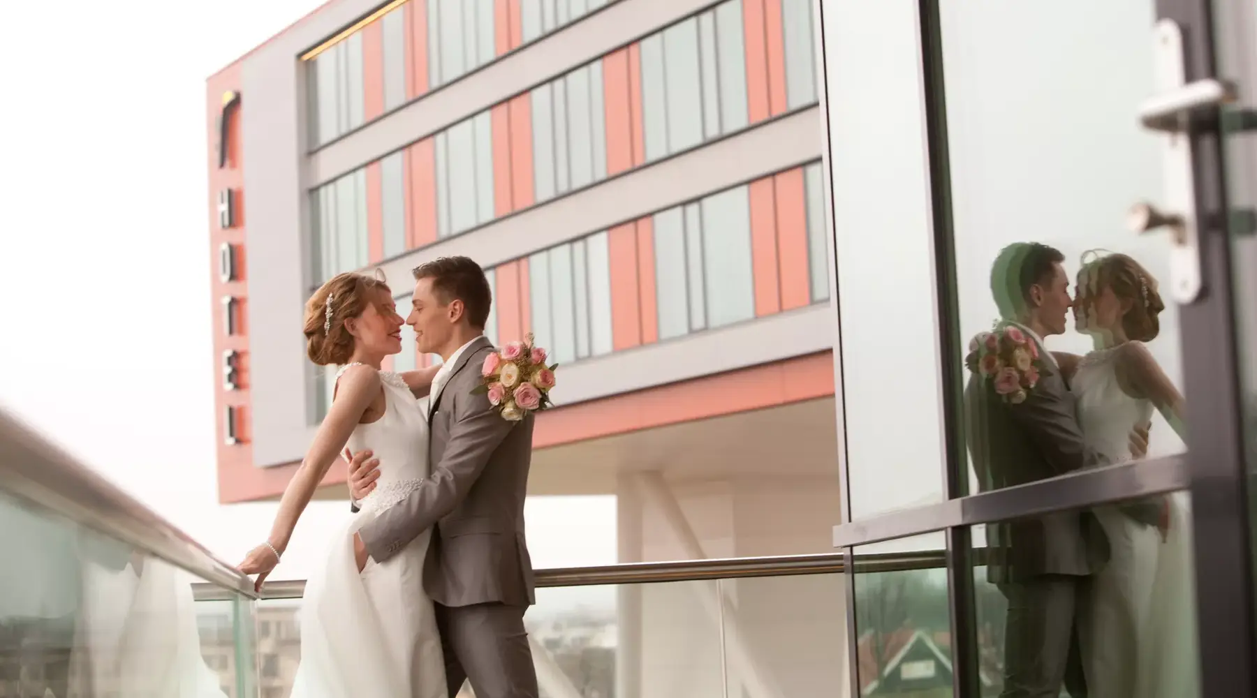 Bruidspaar met hotel op de achtergrond