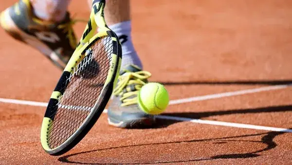 Person on the court with racket and ball.
