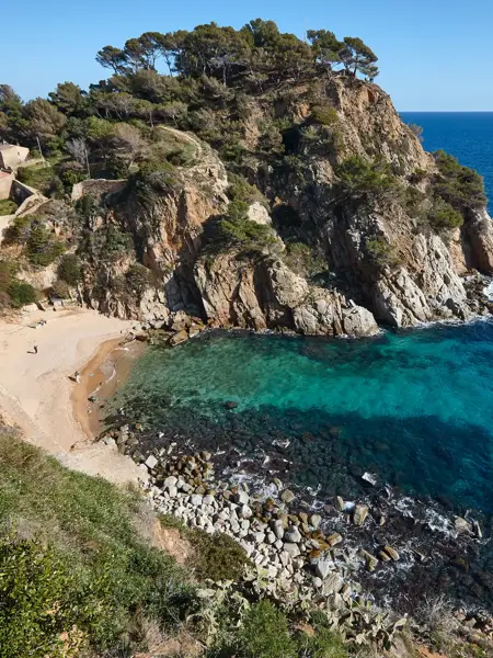 Una bahía de la Costa Brava que refleja las aguas cristalinas de color azul turquesa.