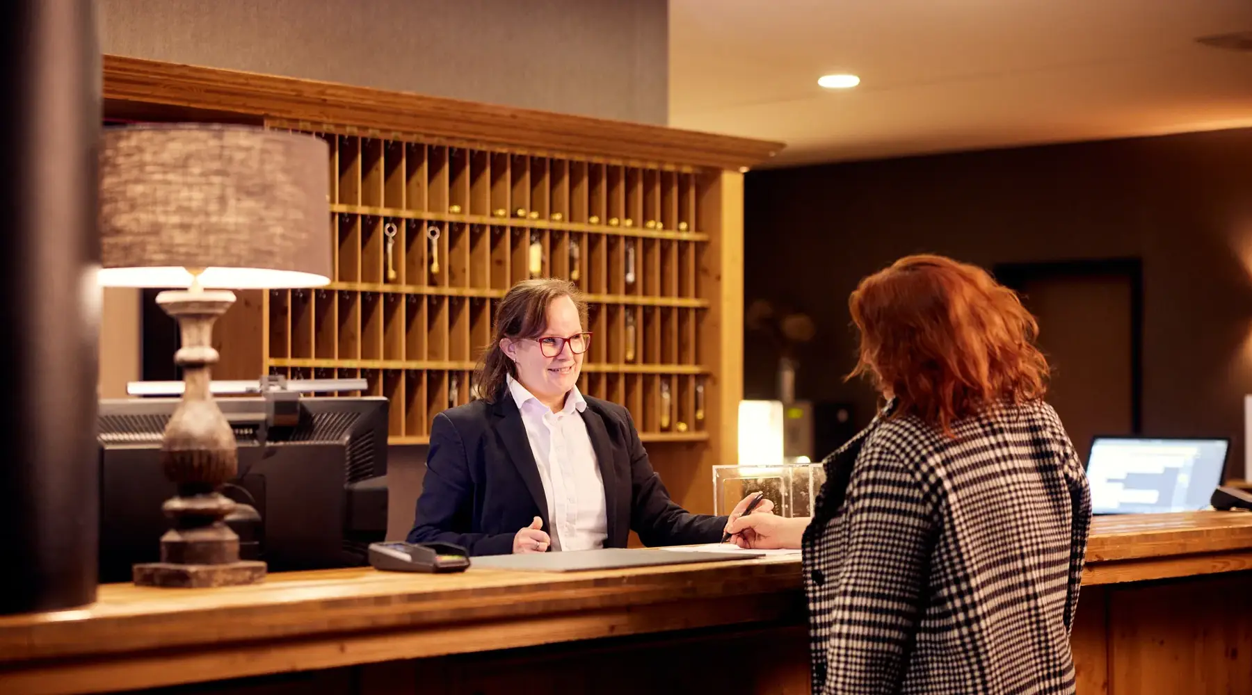 Vriendinnen checken in bij de receptie van een hotel