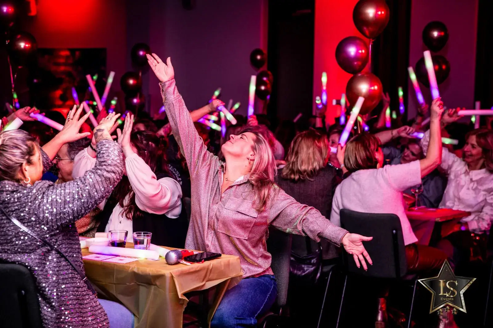 Feestende mensen met lichtjes en ballonnen tijdens een bingo of quiz-avond in Hotel Hoorn