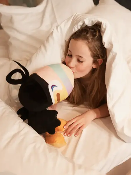 Fille câlinant une peluche Toucan