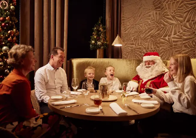 Gezin aan tafel met kerstman