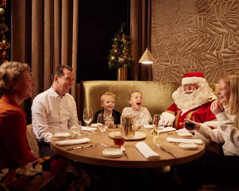 Kerstman met gezin aan tafel