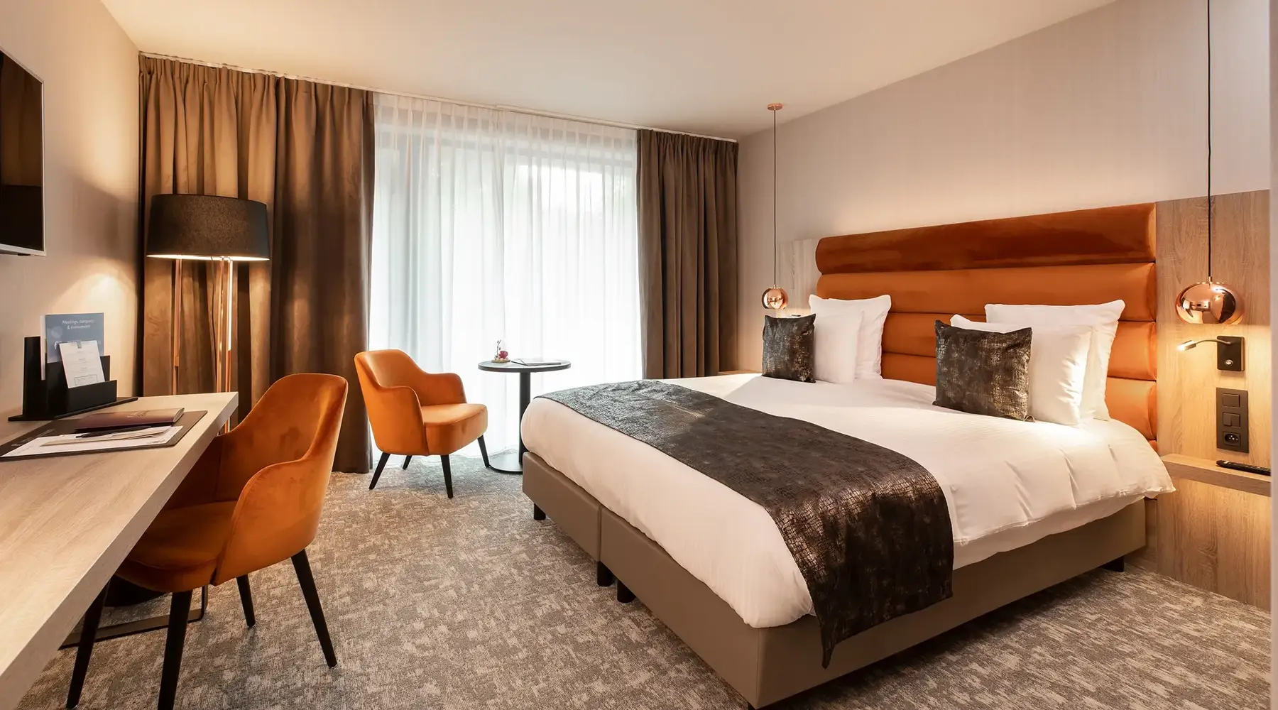 Chambre d'hôtel spacieuse et moderne au Van der Valk Nivelles-Sud avec lit king-size et décoration élégante.