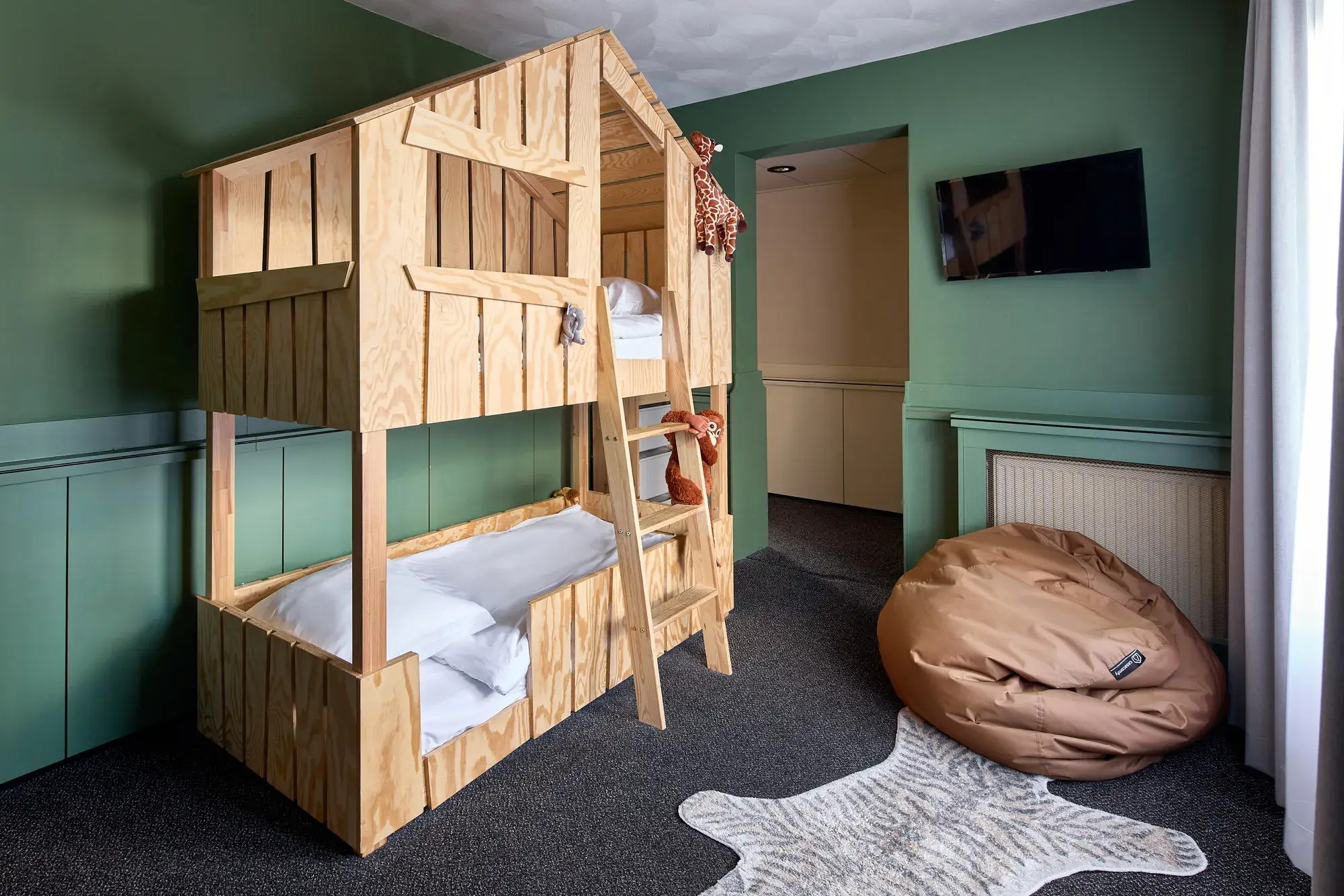 Speelse kinderslaaphoek met stapelbed en junglethema in de familiekamer van Van der Valk Hotel Leusden-Amersfoort