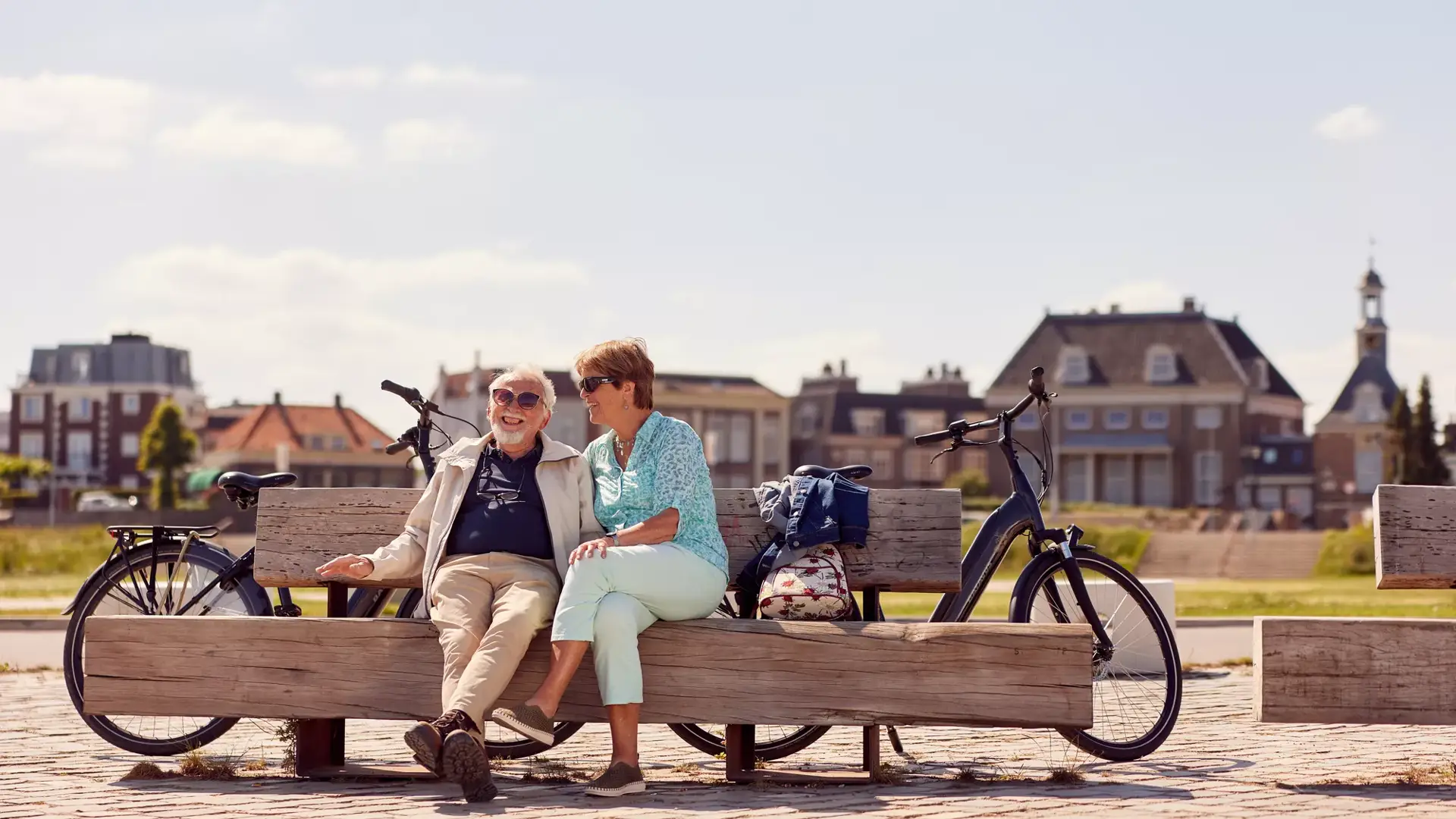 Two seniors are sitting on a bench.