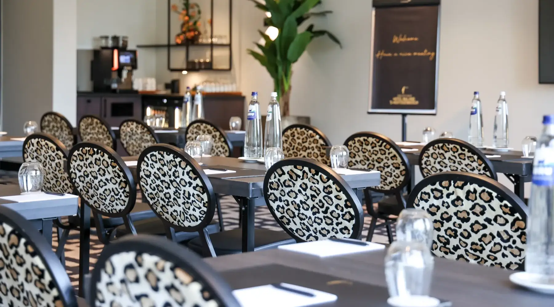 Salle en configuration cabaret à l'Hôtel Nuland - 's-Hertogenbosch. Les chaises ont un motif léopard.