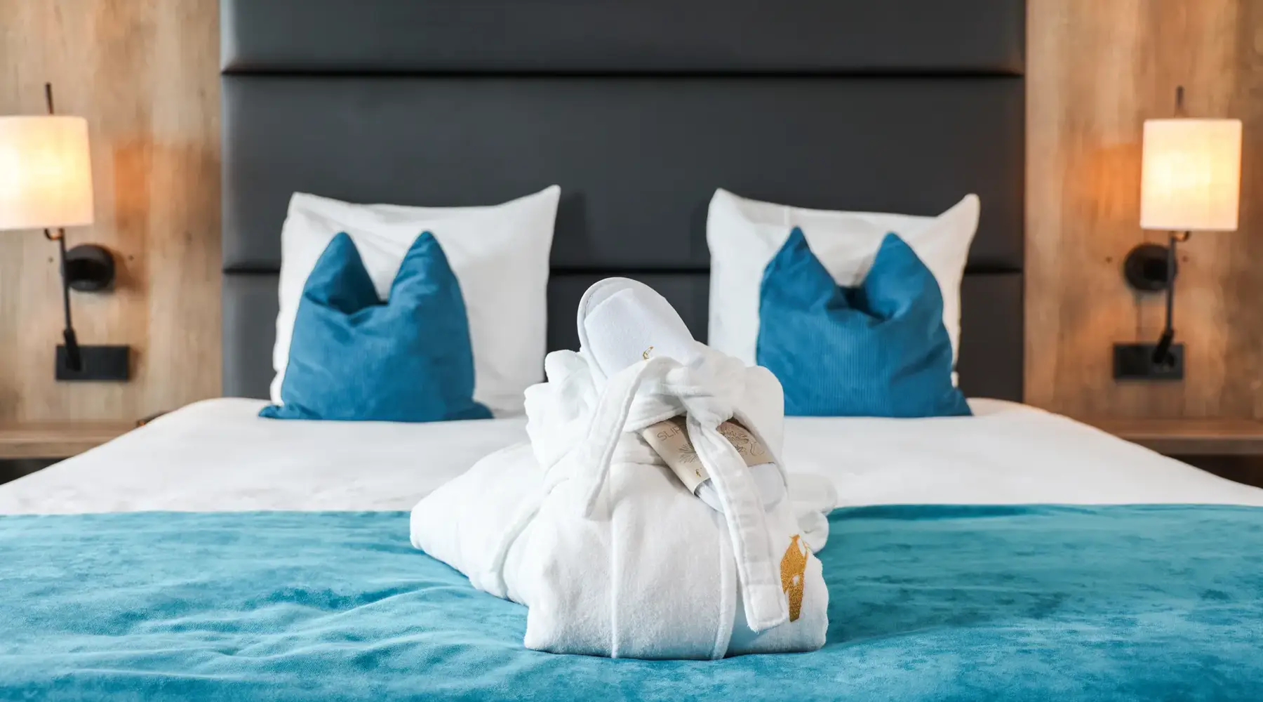 Badjas en slippers op een hotelbed