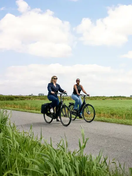Ehepaar geht mit Fahrrad in der Hand spazieren