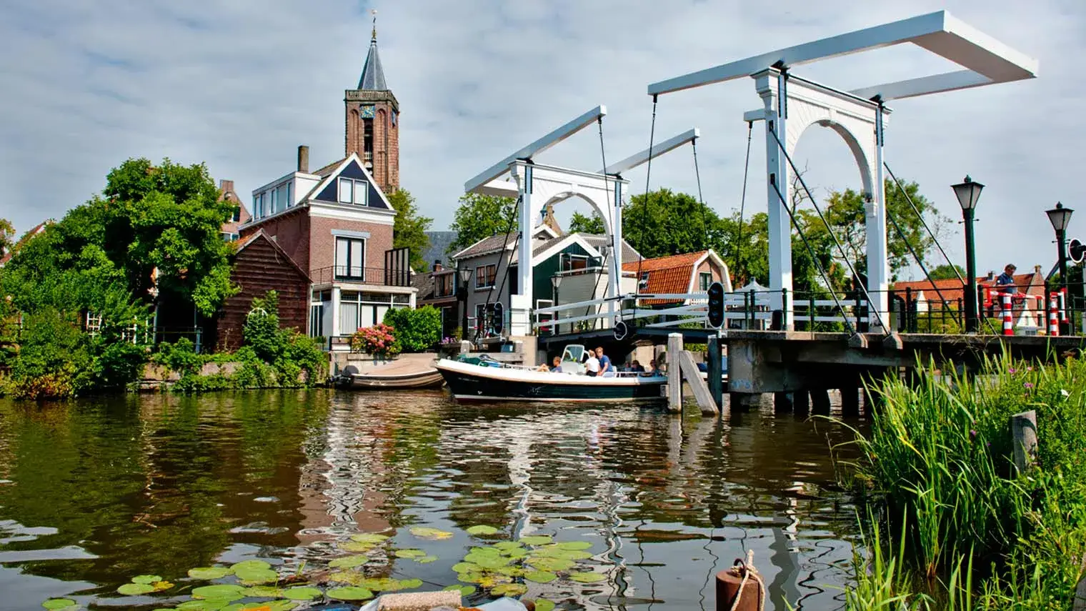 Boot vaart onder brug door in centrum van Breukelen