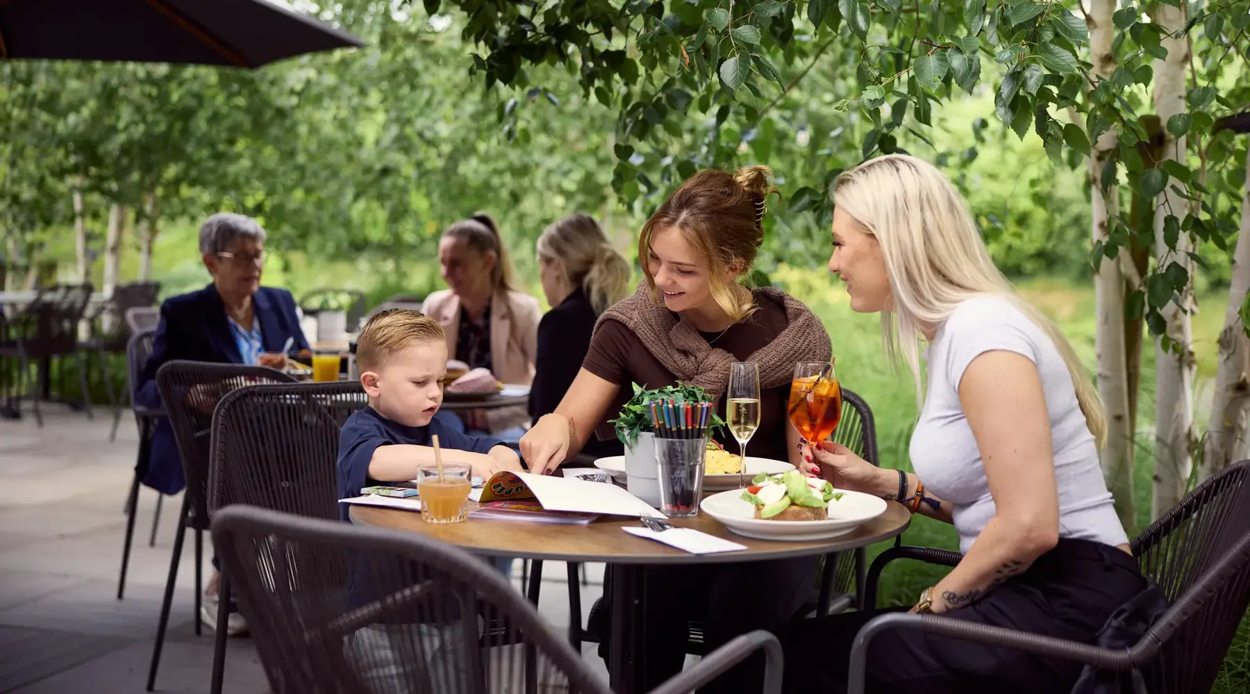 Freunde sitzen auf der Terrasse eines Hotels.