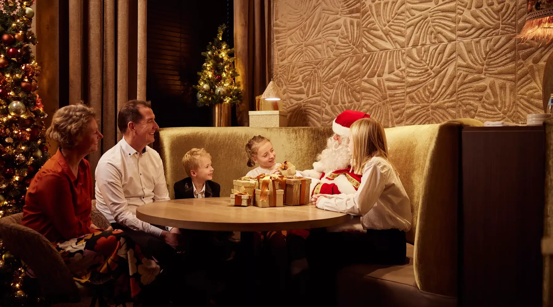 Famille à table avec le Père Noël dans un hôtel Van der Valk