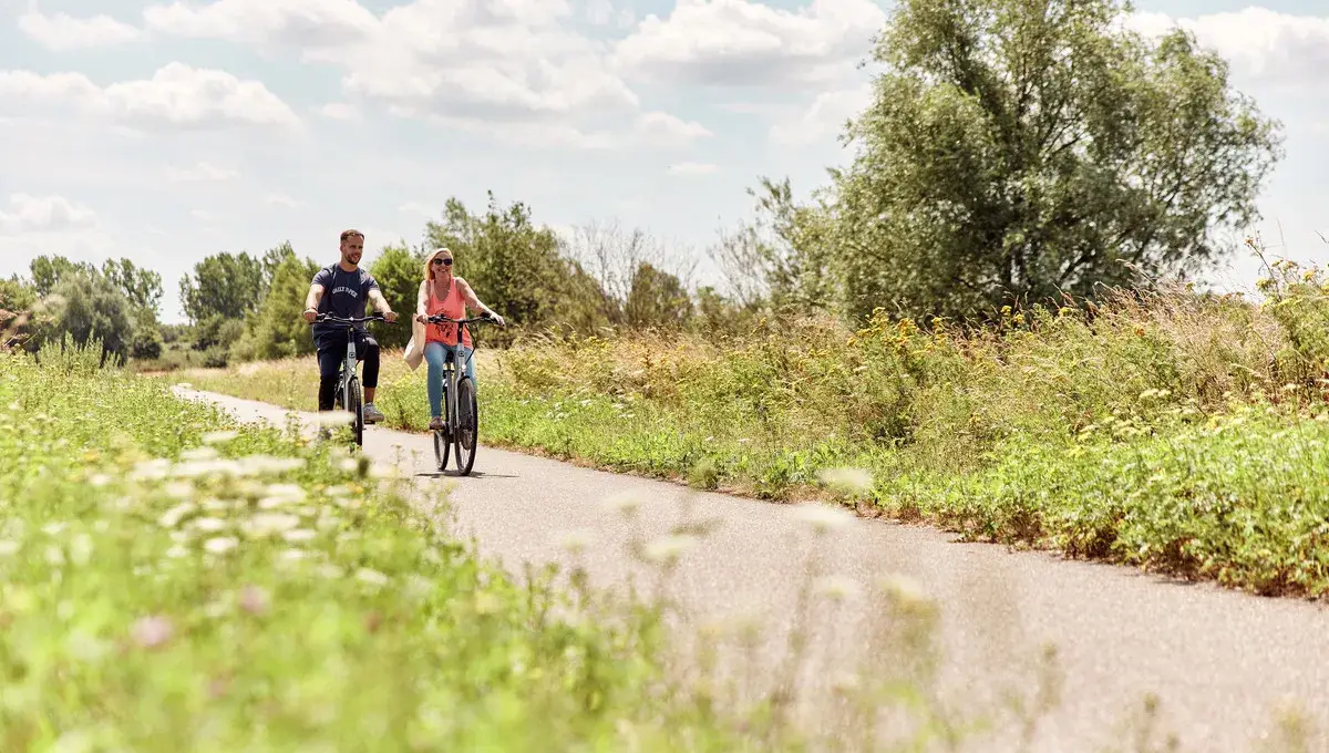 Man and woman cycling through nature