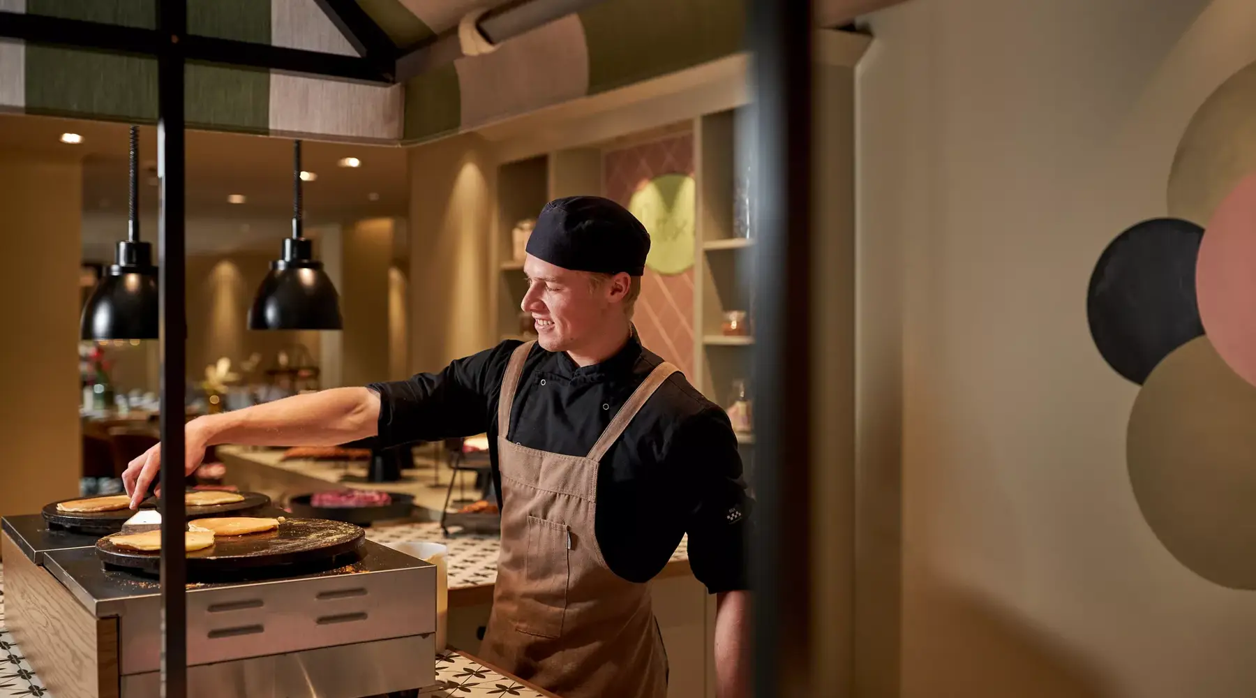 Kok bakt pannenkoekjes voor buffet.
