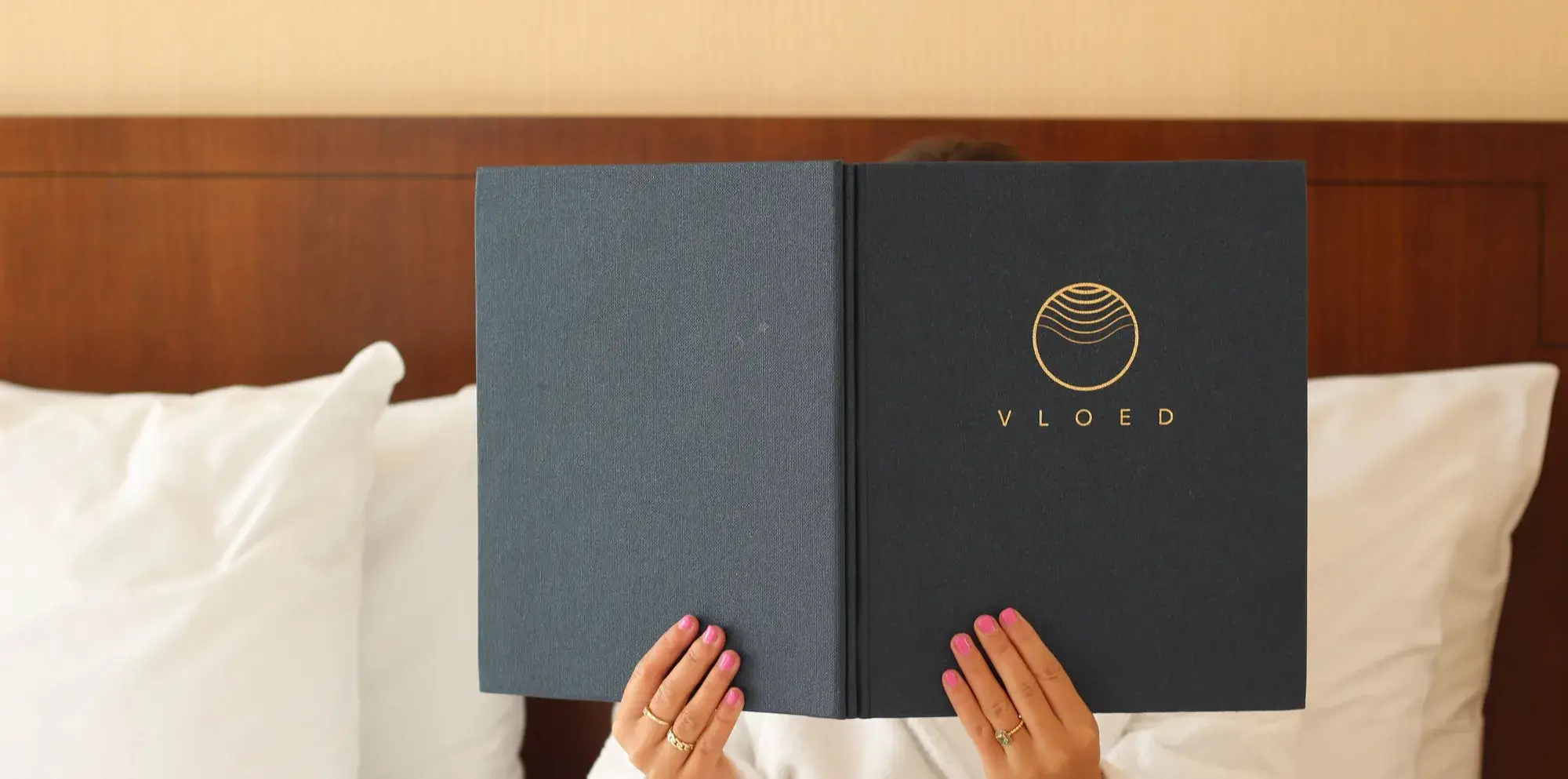 Vrouw houdt menukaart vast in bed in een hotelkamer