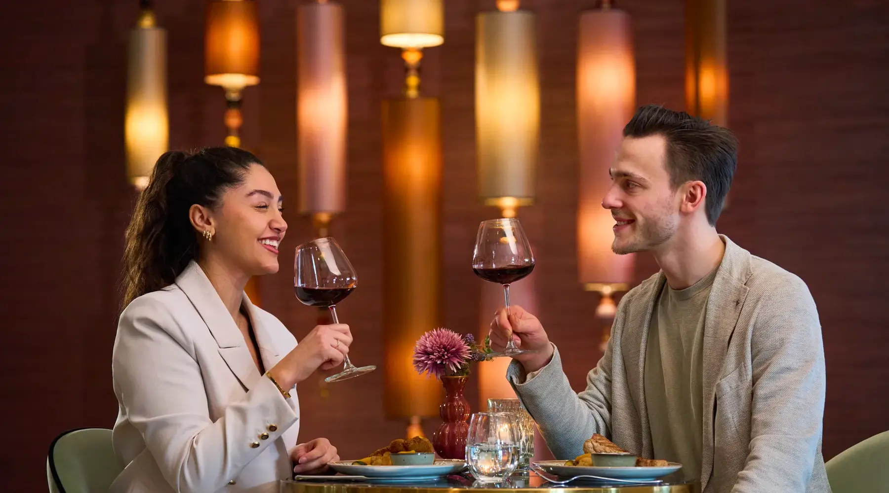Man en vrouw drinken wijn tijdens een diner bij Van der Valk
