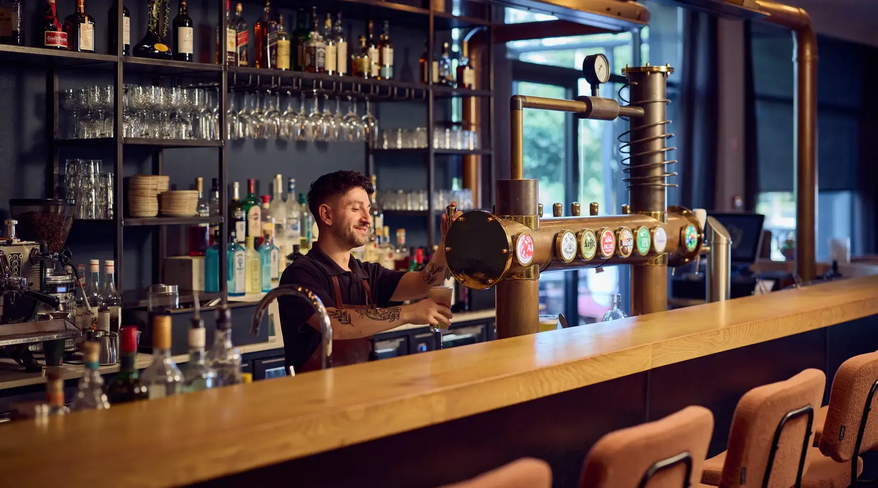 werknemer achter de bar tapt een biertje