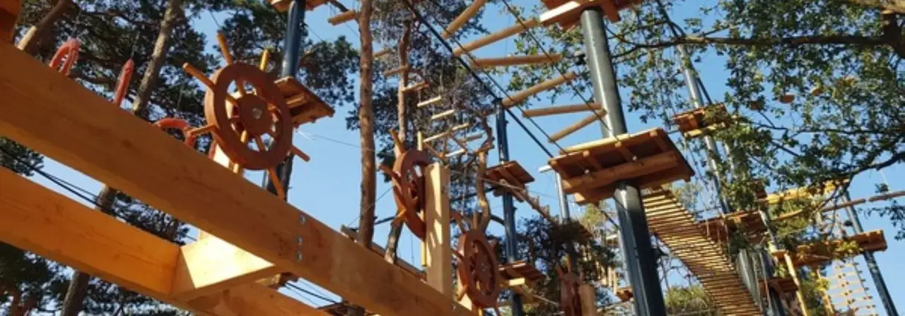 Anspruchsvoller Kletterpark im Freien mit Holzplattformen und Hindernissen zwischen den Bäumen, als Teil der Abenteueraktivitäten während der Outdoor-Woche des IJM.