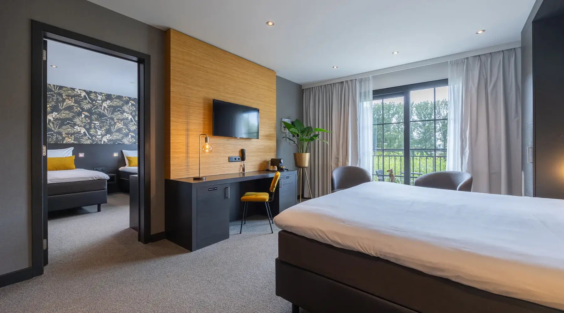 Room with 3 beds, also a desk with chair is present in the room against the wall.