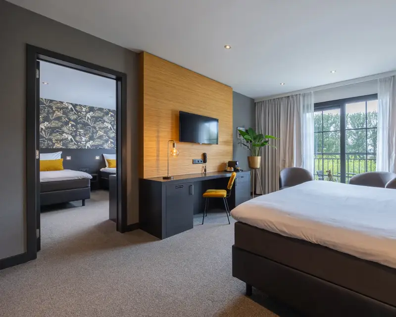 Room with 3 beds, also a desk with chair is present in the room against the wall.