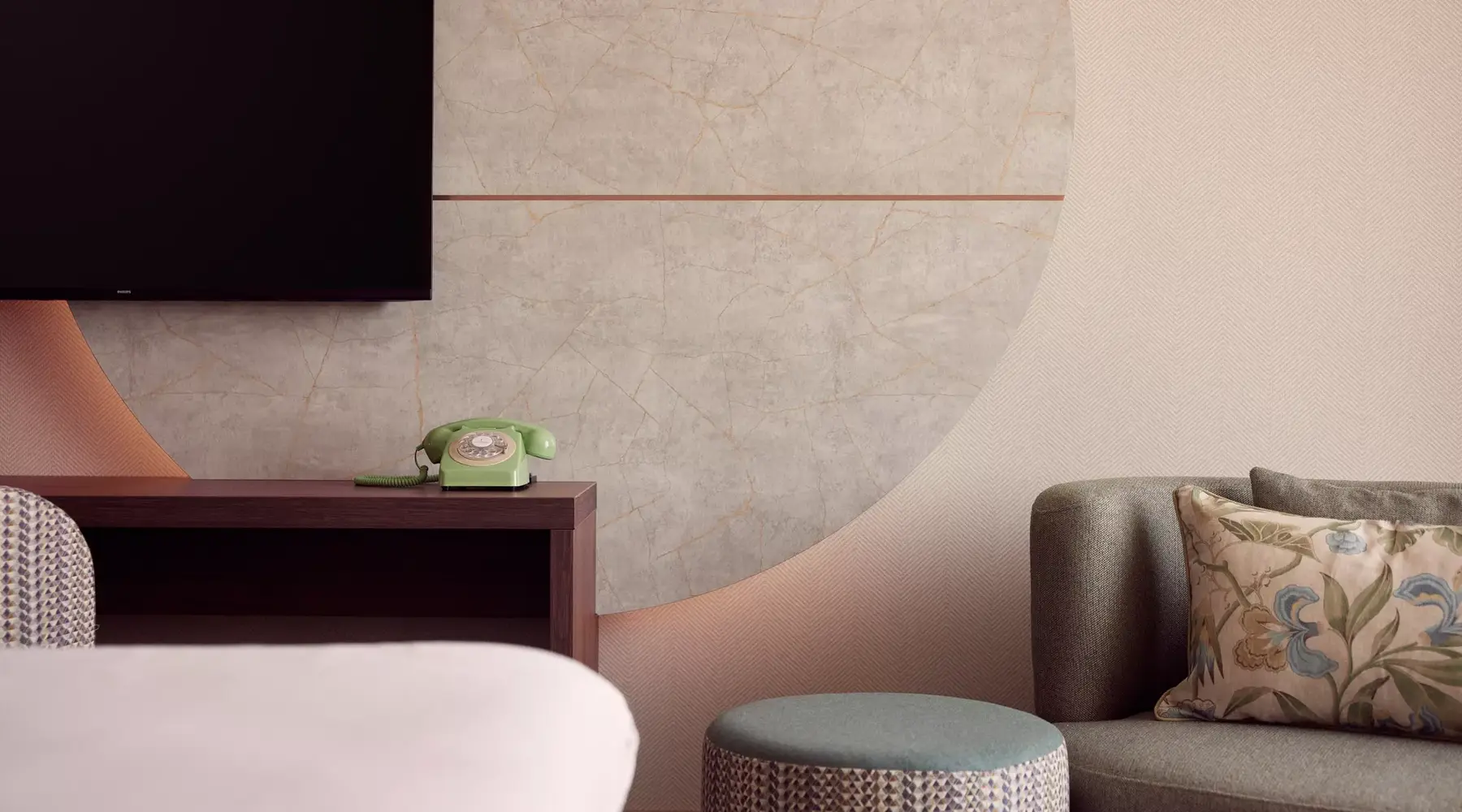 hoekje van de hotelkamer met tv en een bankje
