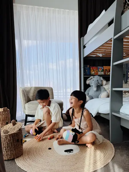 Deux enfants jouent et se détendent dans le parc à proximité du Van der Valk Hotel Gand, entourés de verdure et d’arbres.