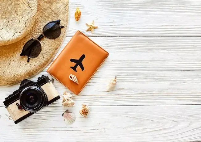 Paspoort, camera en zonnenbril op tafel