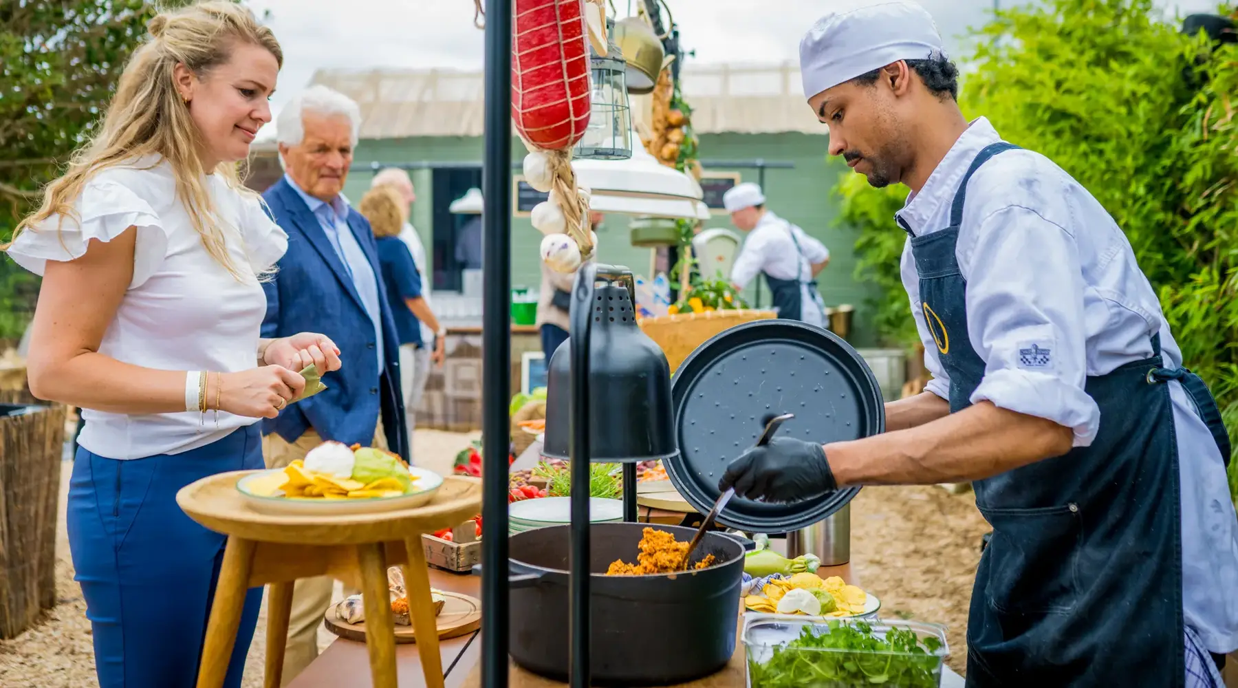 Business barbecue. Chef serves dishes to guests.