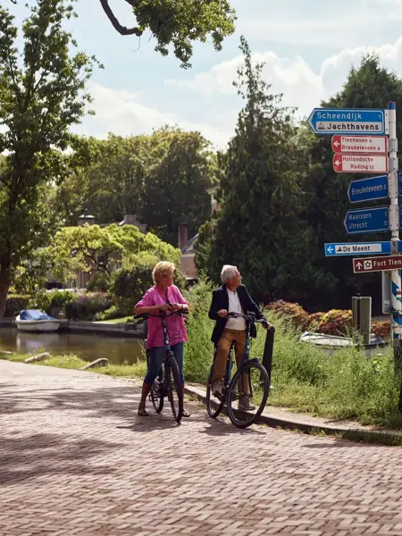 Paar auf dem Fahrrad schaut auf Beschilderung