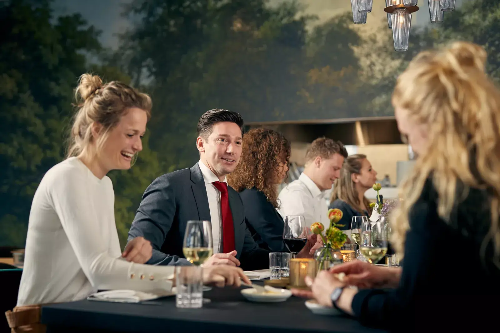 Groep mensen aan tafel tijdens de lunch na een vergadering