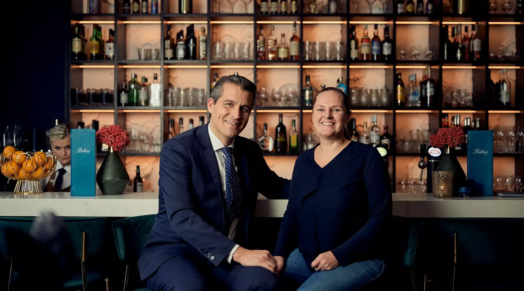 Kees and Bernadette are sitting at the bar and posing for the photo.