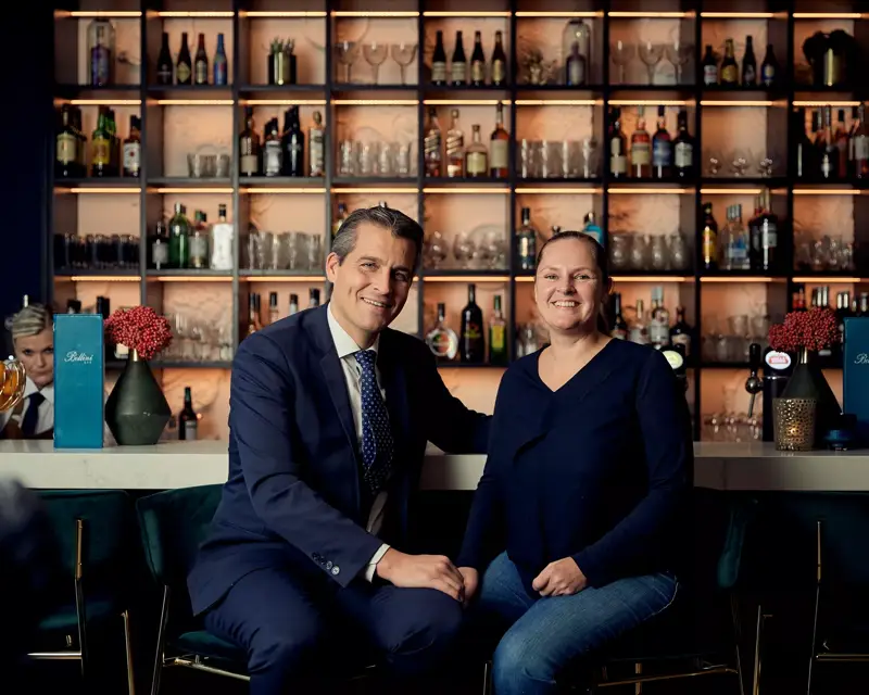 Kees en Bernadette zitten aan de bar en poseren voor de foto