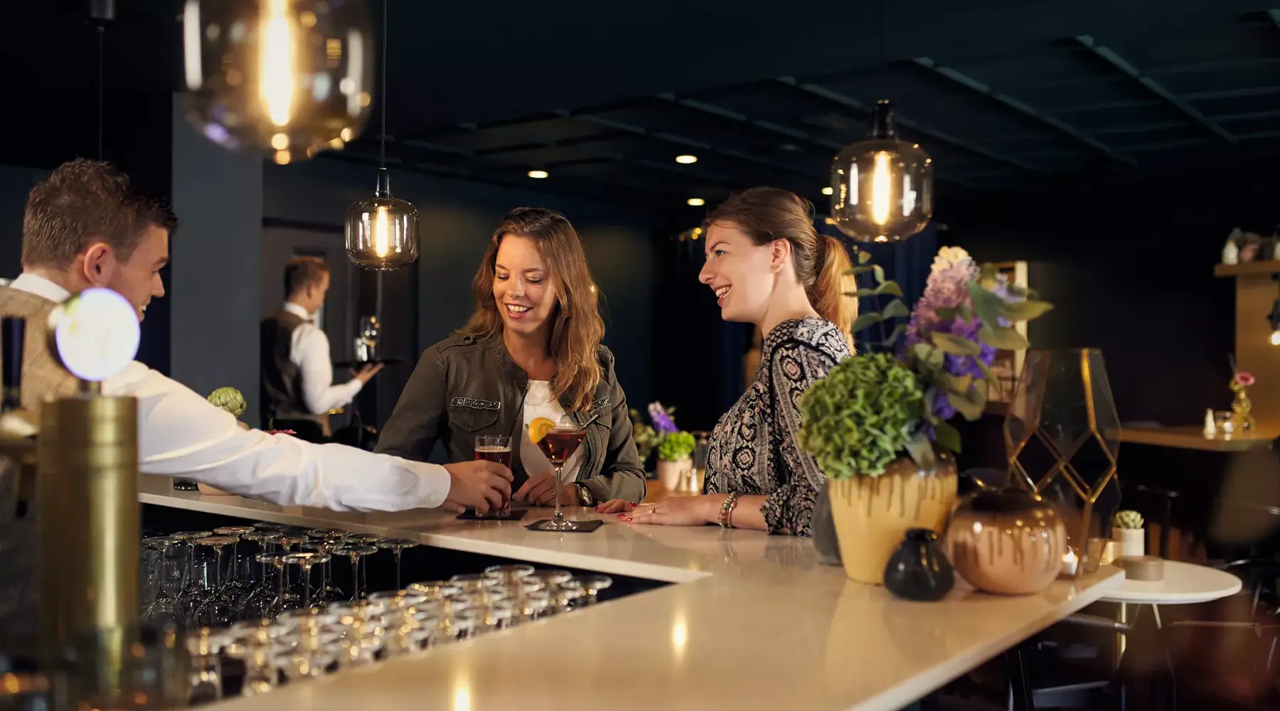 2 dames drinken een drankje aan de bar van Hotel Hardegarijp