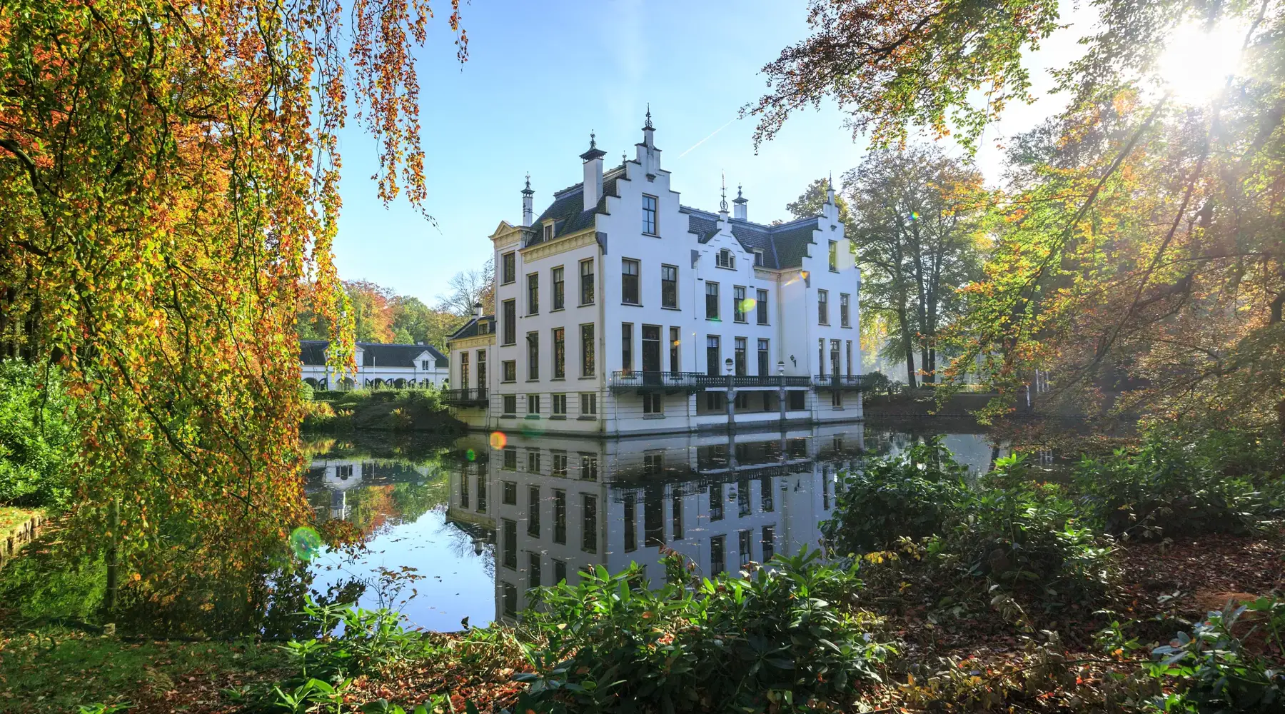 Aanzicht van het witte Kasteel Staverden omringd door water
