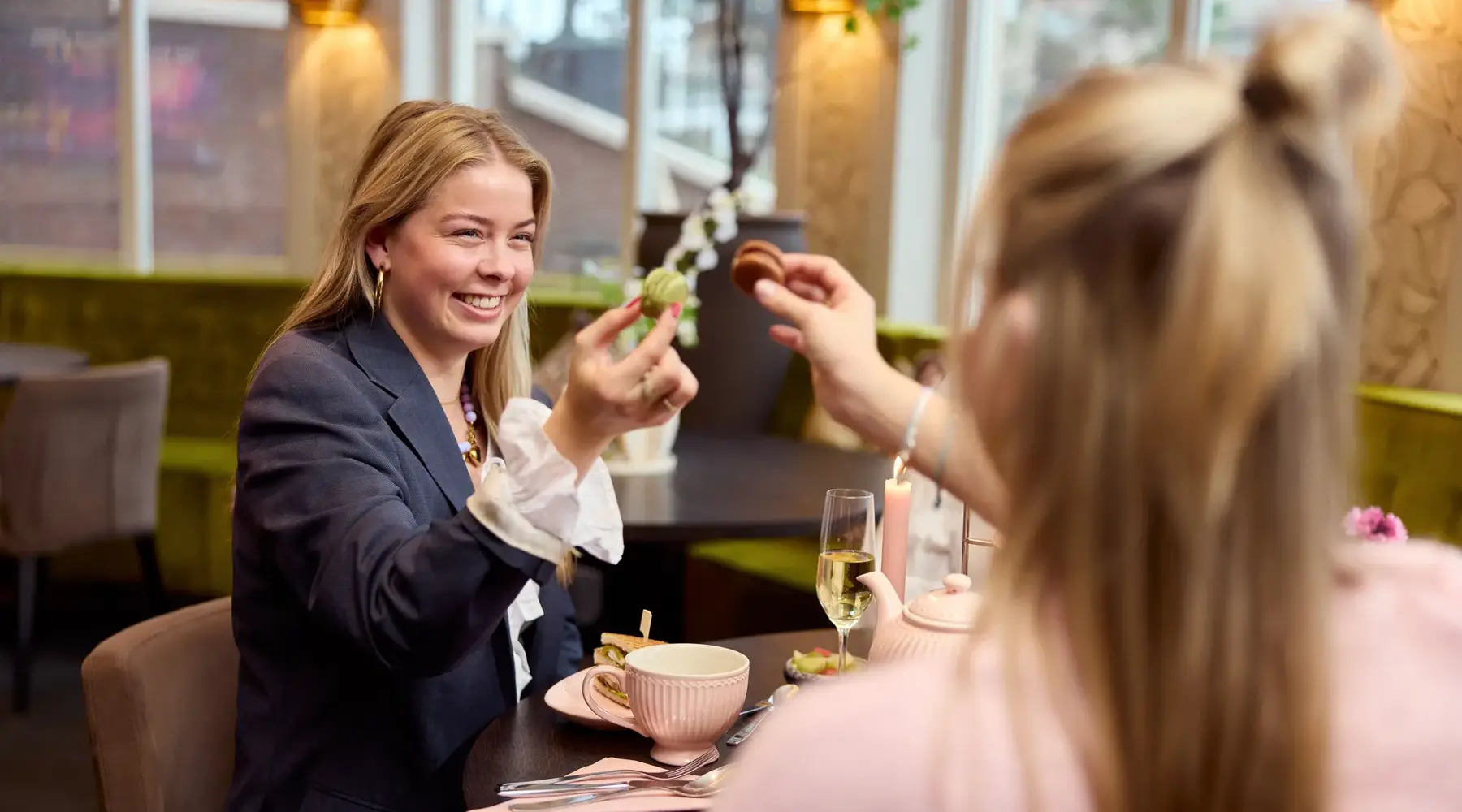 Anstoßen mit einem Macaron während des Nachmittagstees