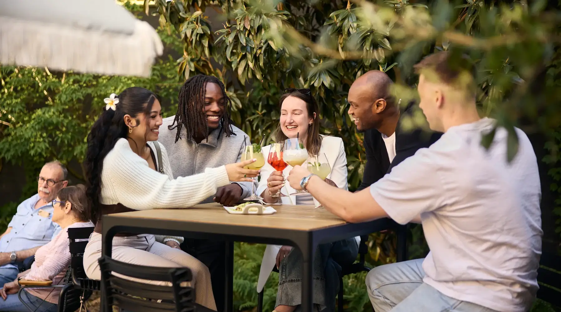 Groupe d'amis trinquant sur une terrasse avec des boissons