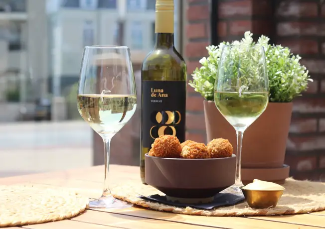 Foto van 2 wijnglazen en bitterballen op het terras