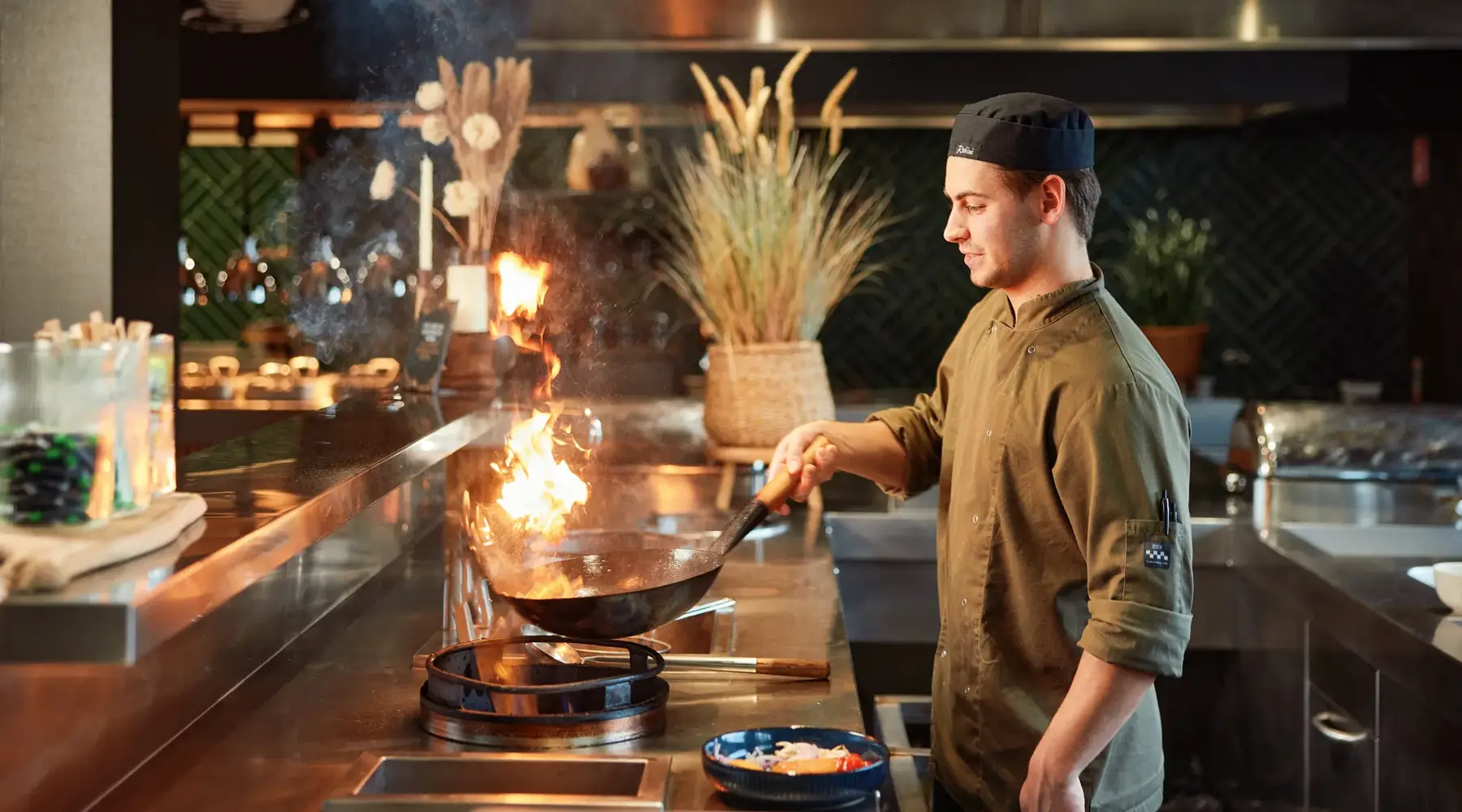 Kok wokt tijdens Live Cooking buffet in Cuijk.
